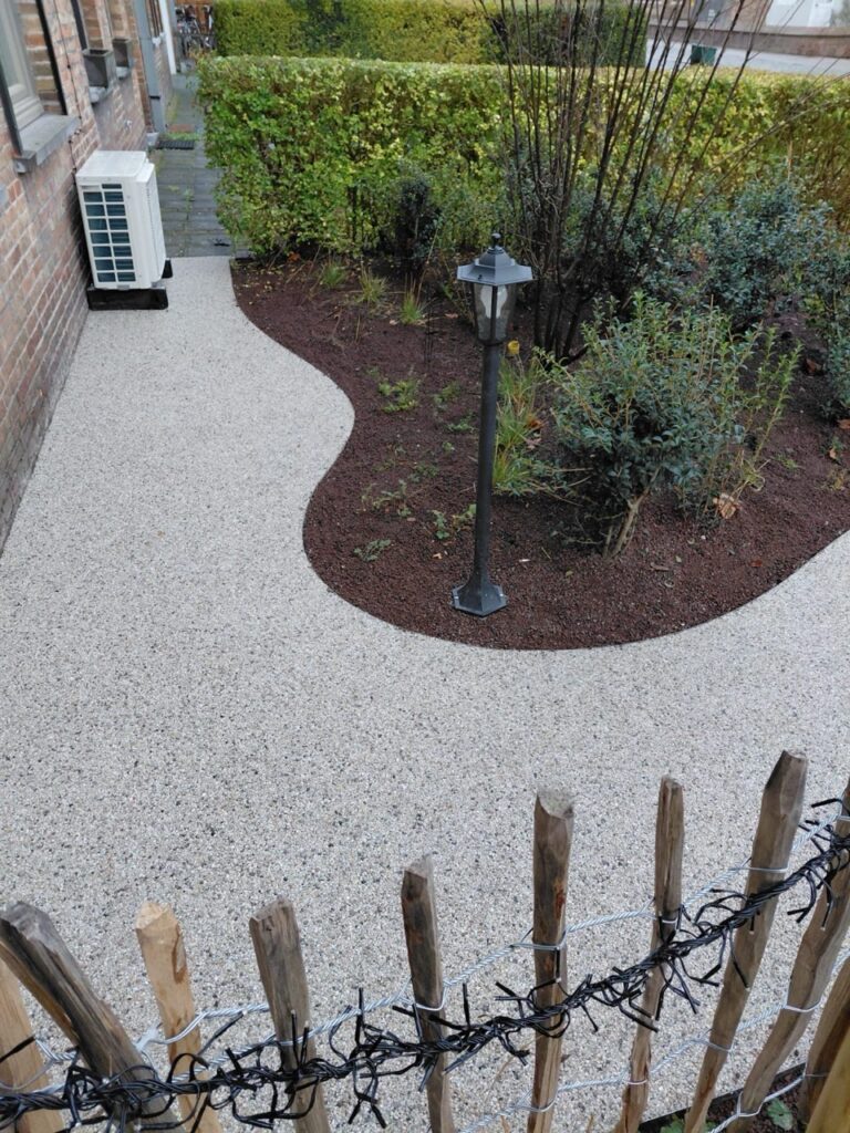 Terradec steentapijt nauwkeurig geplaatst door Xtraverde naast tuin en plantenbak met lantaarn